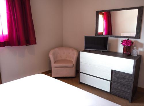 a bedroom with a dresser and a mirror and a chair at Villa Attoni Di Canossa in Anzio