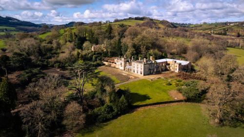 an aerial view of a house on a green field at Llanerchydol Hall Suites in Welshpool