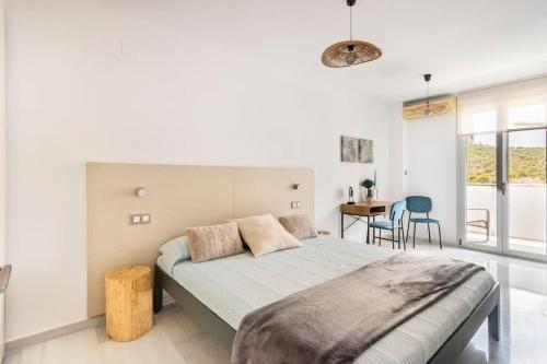 een slaapkamer met een bed en een tafel met stoelen bij Casa Claire in Cala de Finestrat