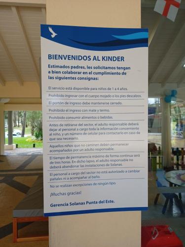 a sign on a column in front of a building at Green Park in Punta del Este