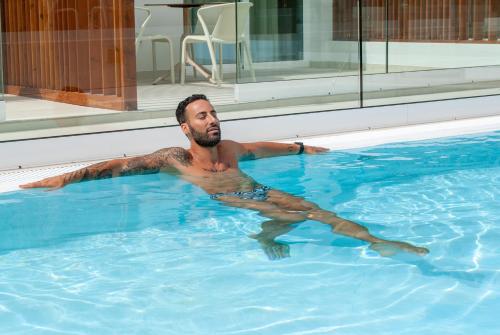 a man is swimming in a swimming pool at MAR BIANCO - Gay Men Only in Maspalomas