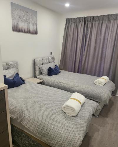 a room with two beds with pillows on them at 3 Bedrooms 2baths 3 toilets Excel City Airport O2 Sleeps up to 7, in London