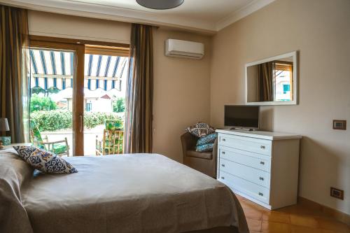 a bedroom with a bed and a dresser with a mirror at Villa Attoni Di Canossa in Anzio