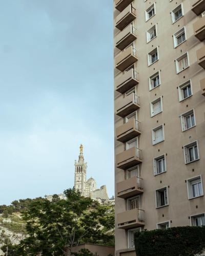 a tall building with a clock tower in the background at Endoume Notre Dame de la Garde T2 avec PARKING in Marseille