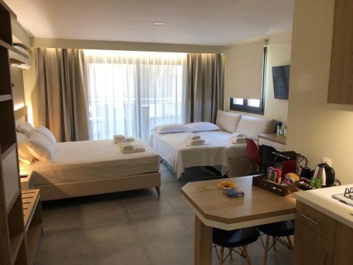 um quarto de hotel com duas camas e uma cozinha em Garden Apartments em Keramotí