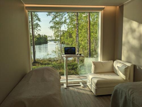 um quarto com uma grande janela com um sofá e uma televisão em Lakehouse Juolas em Mäntyharju