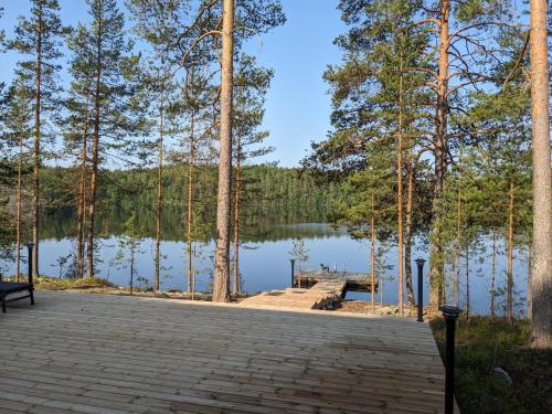 a dock in front of a lake with trees at Lakehouse Juolas in Mäntyharju