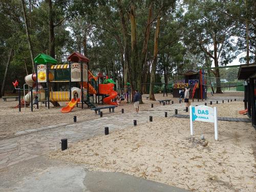 a playground in a park with a sign in the sand at Green Park in Punta del Este