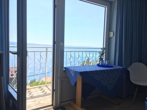 uma varanda com uma mesa azul e vista para o oceano em CASA QUARTO - Vacation Home - 4 Appartements em Omiš