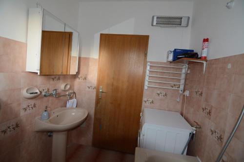 a bathroom with a sink and a toilet and a mirror at Garden Apartment Braut in Kornić