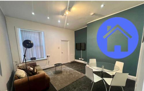 a living room with a table and a blue sign on the wall at Spacious 2bedroom property by Star Suites in Elswick