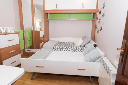 Dormitorio pequeño con cama y armario en VelayLi - Apartamento en el centro de Finisterre en Finisterre