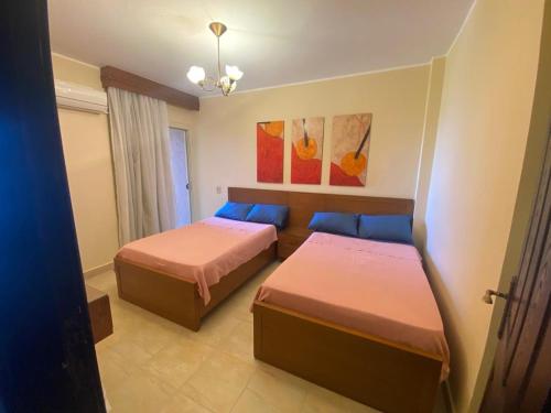a bedroom with two beds and a window at Blumar North Coast in El Alamein