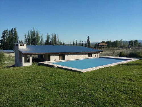 a swimming pool in the middle of a grass field at Kairos Cabañas in Las Compuertas