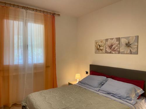 a bedroom with a bed with two paintings on the wall at Mare e natura a Nisportino in Casa Castagno