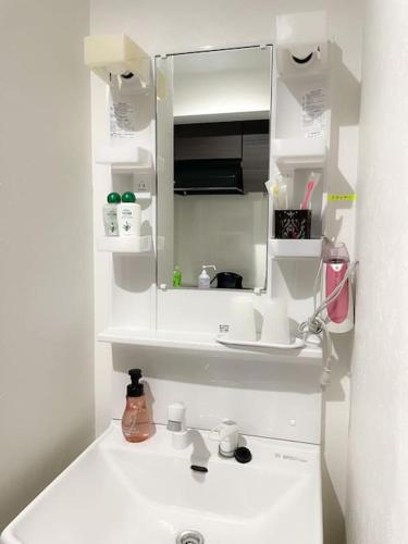a white bathroom with a sink and a mirror at 203 Oshiage sta 3mins walk! Wi-Fi Elevator 4pax in Tokyo