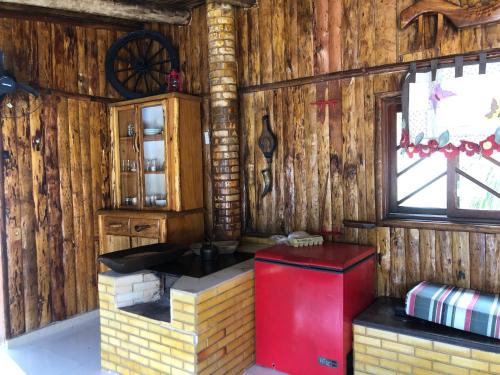 a red refrigerator in a room with wooden walls at RECANTO VERDES VALES in Palhoça
