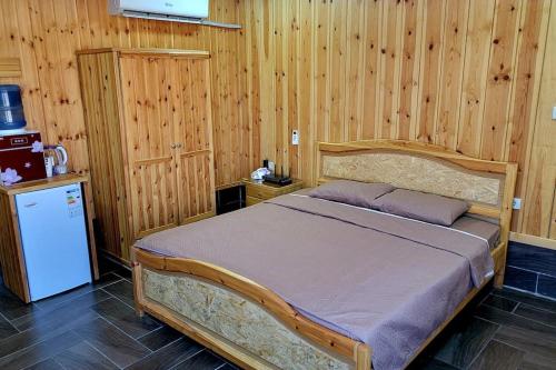 een slaapkamer met een bed in een houten kamer bij atoom lodge in Jerash