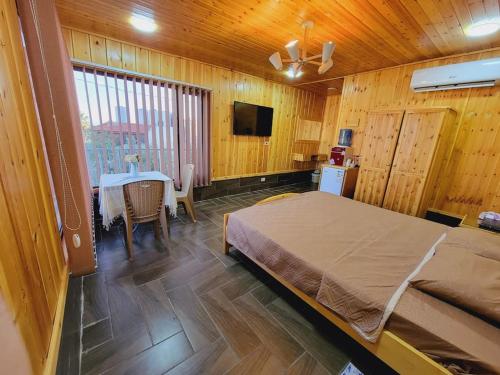a bedroom with a bed and a table and a television at atoom lodge in Jerash
