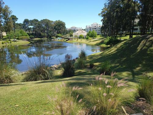 a pond in a park with a bridge over it at Green Park in Punta del Este
