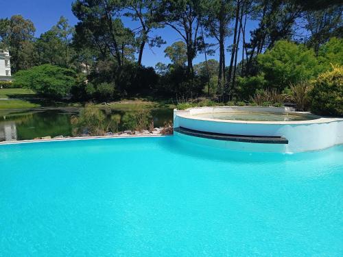 a swimming pool with blue water in a yard at Green Park in Punta del Este