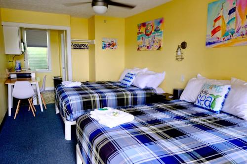2 camas en una habitación con paredes amarillas en Dock House Inn, en Old Orchard Beach