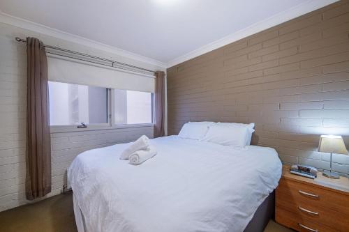 a bedroom with a large white bed with a window at Snow Ski Apartments 30 in Falls Creek