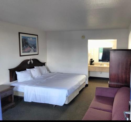 索爾茲伯里的住宿－索爾茲伯里美國最有價值旅館，卧室配有一张白色的大床和一张沙发。