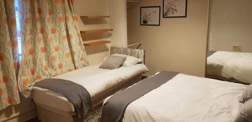 sypialnia z 2 łóżkami i lustrem w obiekcie Arise Comfort Home - Dumers Lane, Radcliffe, Bury, Manchester w mieście Radcliffe