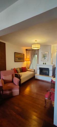 a living room with a couch and a fireplace at Vintage House by the Sea in Chorefto