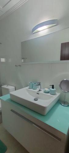 a white bathroom with a sink and a stool at Vintage House by the Sea in Chorefto
