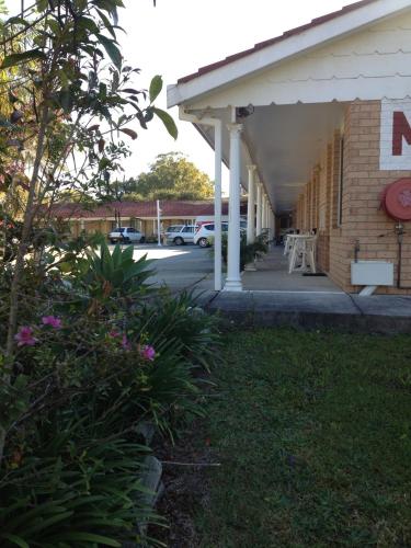 a front porch of a building with a parking lot at Palms Oasis Motel in Coopernook