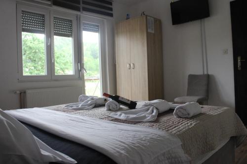 a bedroom with a bed with towels on it at Apartmani Ramonda in Teslić