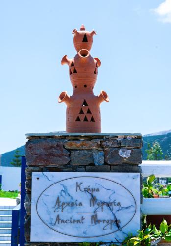 a teddy bear sitting on top of a sign at ANCIENT MEROPIA - Les jardins des muses in Apollonia