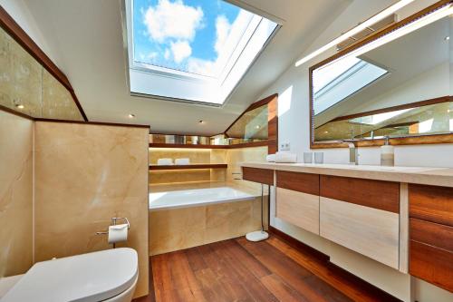 a bathroom with a skylight and a tub and a toilet at Das Gsteig in Garmisch-Partenkirchen