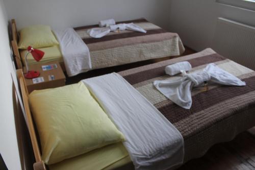 two beds in a room with towels on them at Apartmani Ramonda in Teslić