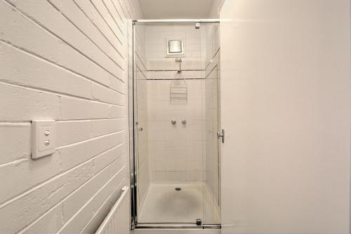a shower with a glass door in a bathroom at Snow Ski Apartments 19 in Falls Creek