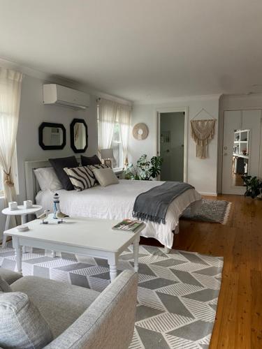 1 dormitorio con cama blanca y mesa de centro blanca en Travellers Retreat Bayview, en Bay View