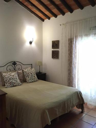 a bedroom with a large bed with a window at Quinta da Trombeta in Borba