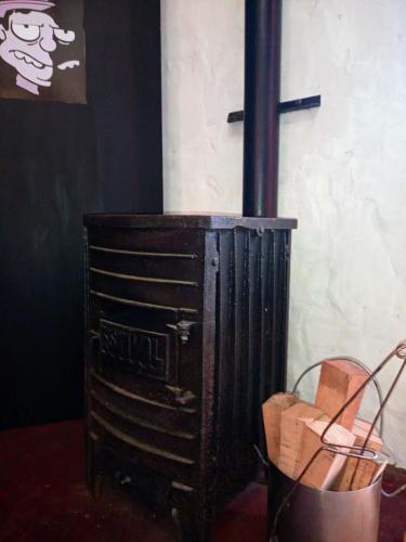 an old woodburning stove in a corner of a room at Casargentina Apart Depto entero Baño privado 15min Ezeiza in Monte Grande