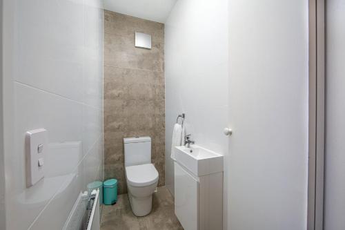 a white bathroom with a toilet and a sink at Snow Ski Apartments 25 in Falls Creek