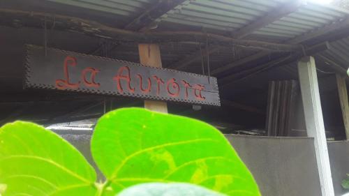 un signo que lee la europuerto con una planta verde en Casa La Aurora "Posada", en Restrepo