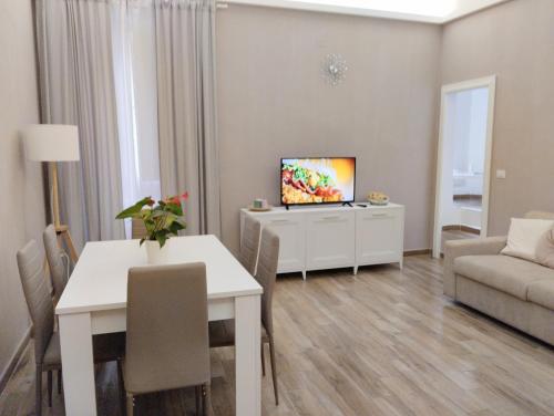 een woonkamer met een televisie, een tafel en een bank bij Abruzzo Holiday in Ortona