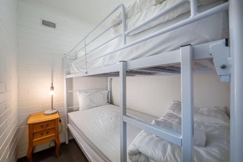 a bedroom with two bunk beds and a table at Snow Ski Apartments 24 in Falls Creek
