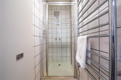 a shower with a glass door in a bathroom at Snow Ski Apartments 24 in Falls Creek