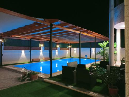 傑里科的住宿－Al bader villa，游泳池在晚上的凉棚下