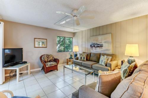 a living room with a couch and a tv at Pool View Beachwood Condo in Fernandina Beach