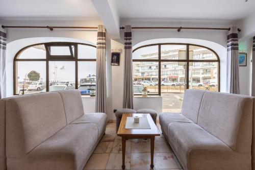 a living room with two couches and a coffee table at Hotel Residencial Salema in Salema