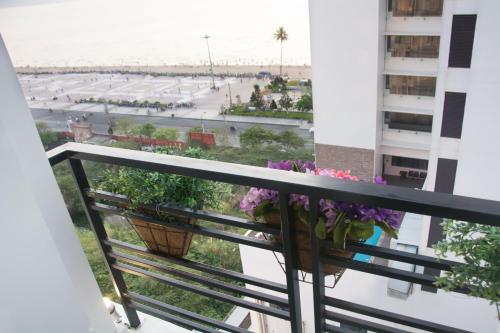 a balcony with flowers and a view of the beach at Pavillon Garden Hotel in Nha Trang