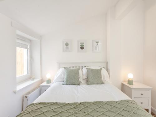 Dove Cottage في إينفيرنيس: غرفة نوم بيضاء بسرير ومصباحين